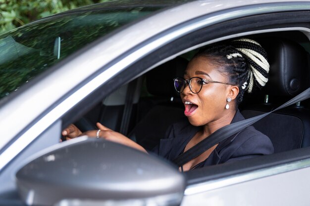 Vista lateral de la mujer emocionada por conducir su coche personal