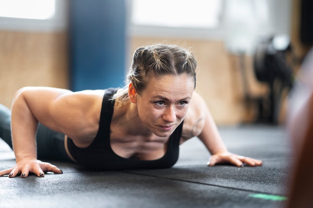 Foto gratuita vista lateral mujer entrenando en el gimnasio