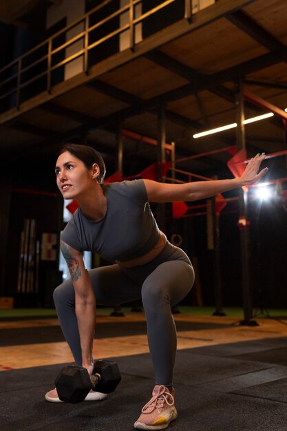 Foto gratuita vista lateral mujer entrenando en el gimnasio