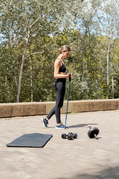 Foto gratuita vista lateral de la mujer con equipo de entrenamiento al aire libre