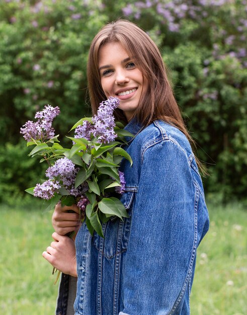 Vista lateral mujer con flores lilas