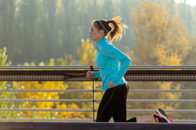 Vista lateral de mujer en forma corriendo al aire libre