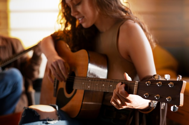 Foto gratuita vista lateral de una mujer con guitarra