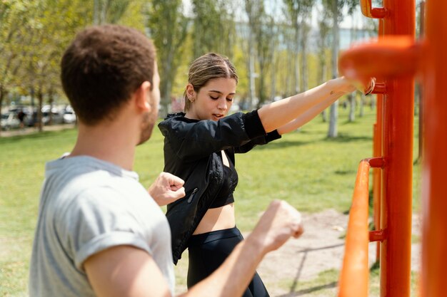 Vista lateral, de, mujer y hombre, ejercitar, juntos, aire libre