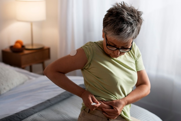 Foto gratuita vista lateral mujer inyectando insulina en casa