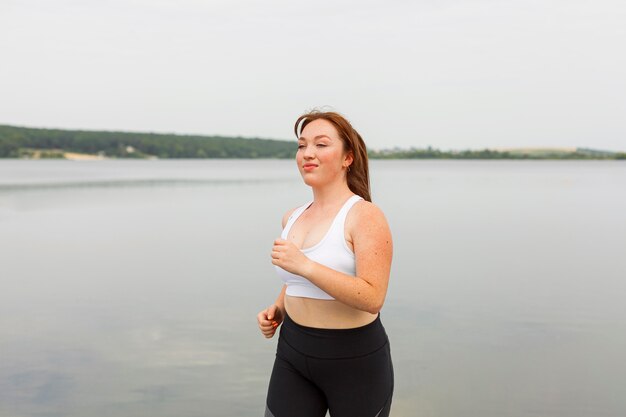 Vista lateral, de, mujer, jogging, aire libre