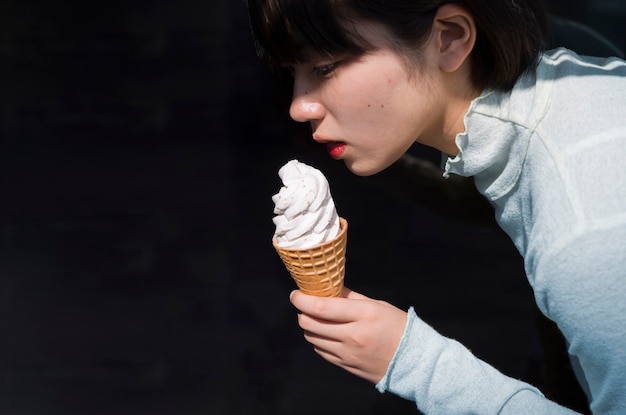 Vista lateral mujer joven con cono de helado