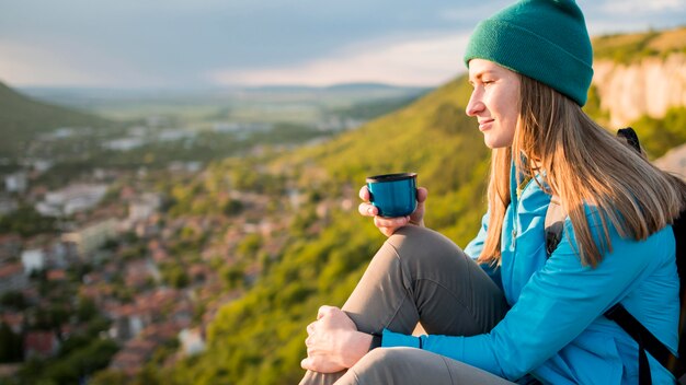 Vista lateral mujer joven con gorro disfrutando viaje