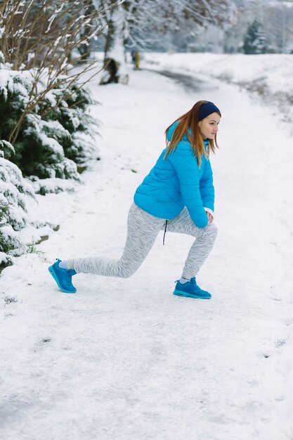 Vista lateral de una mujer joven haciendo ejercicio en invierno