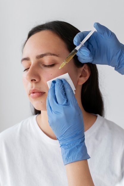 Vista lateral mujer joven recibiendo tratamiento prp facial