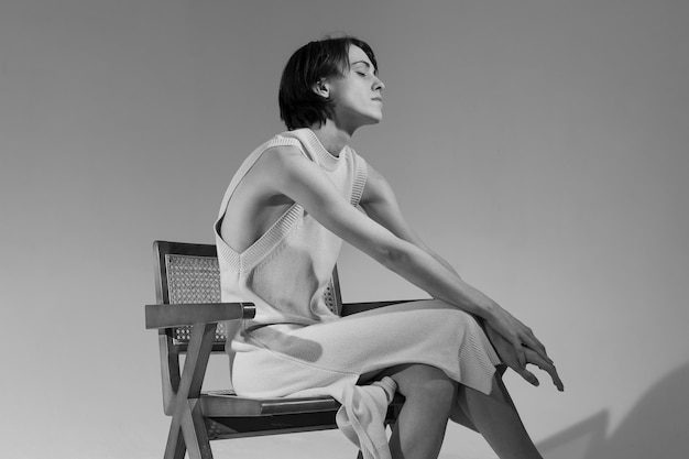 Foto gratuita vista lateral, mujer joven, sentado, en, silla