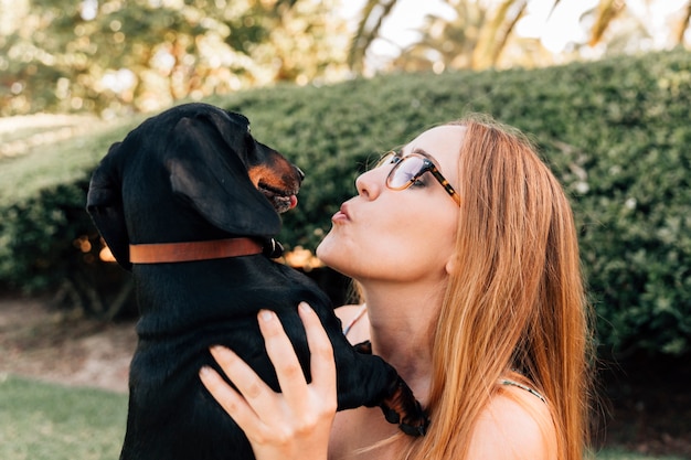 Vista lateral de una mujer joven con su perro en el parque