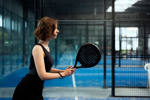 Vista lateral mujer jugando padel