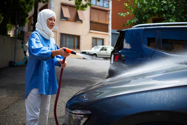 Vista lateral mujer lavando auto