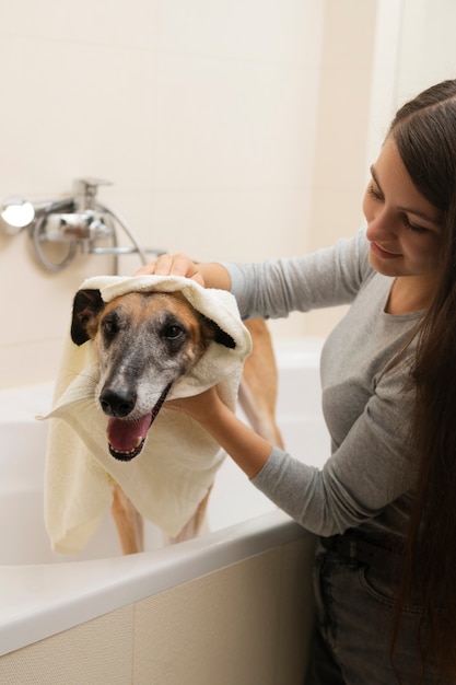 Vista lateral mujer lavando perro