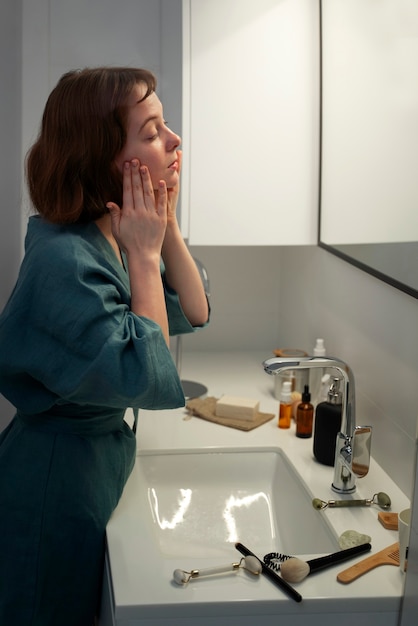 Foto gratuita vista lateral mujer masajeando la cara en casa