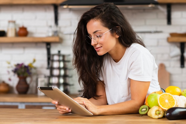 Foto gratuita vista lateral mujer morena con tableta