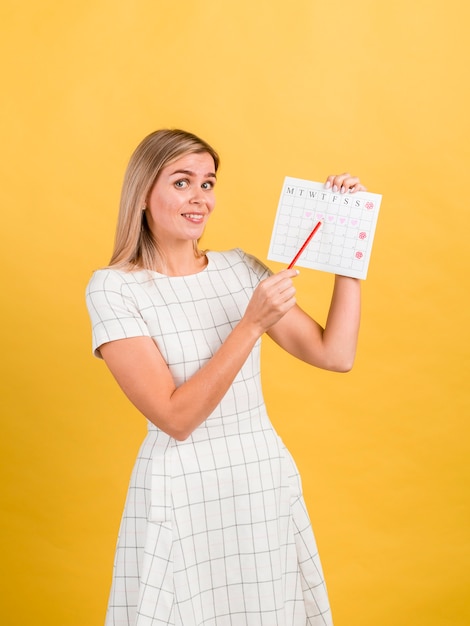 Foto gratuita vista lateral mujer mostrando su calendario de período