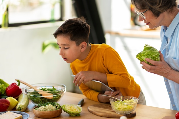 Vista lateral mujer y niño cocinando juntos