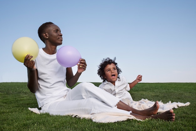 Foto gratuita vista lateral mujer y niño con globos.