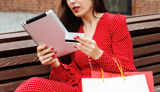 Vista lateral de la mujer con ordenador portátil y compra online con tarjeta de crédito