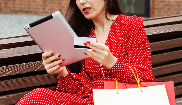 Vista lateral de la mujer con ordenador portátil y compra online con tarjeta de crédito