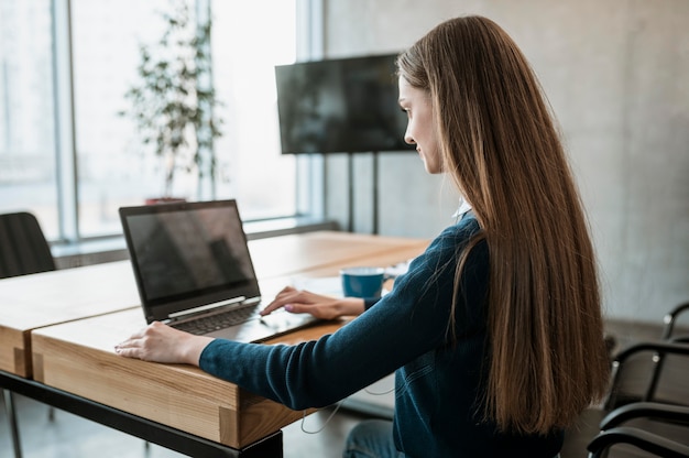 Foto gratuita vista lateral de la mujer con portátil preparándose para una reunión