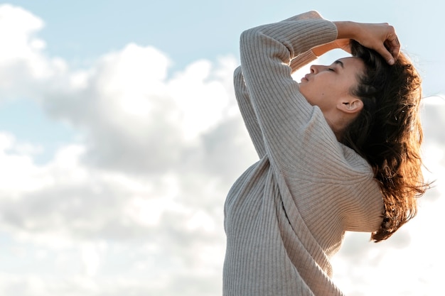 Foto gratuita vista lateral de la mujer posando contra el cielo con espacio de copia