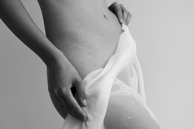 Vista lateral mujer posando desnuda con paño húmedo