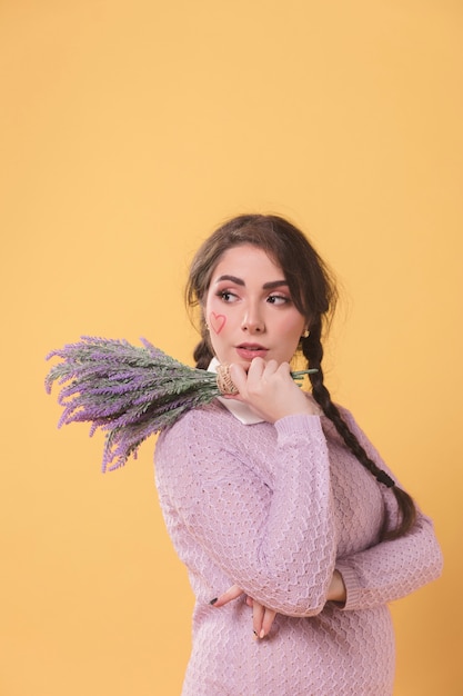 Foto gratuita vista lateral de la mujer posando mientras sostiene lavanda