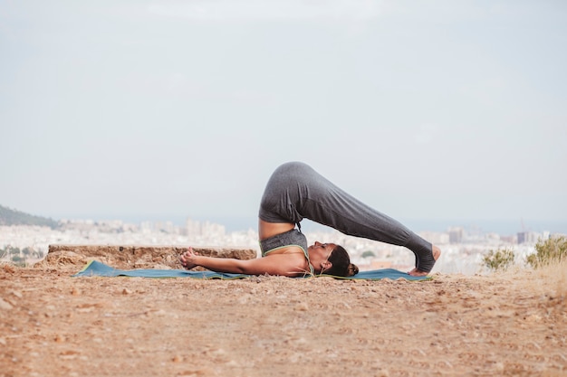 Foto gratuita vista lateral de mujer en postura de yoga