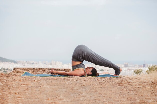 Vista lateral de mujer en postura de yoga