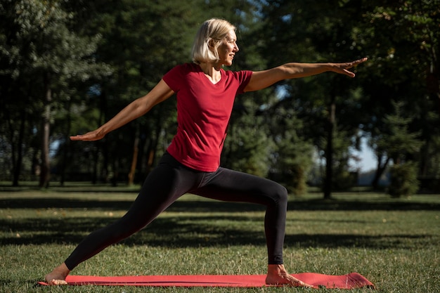 Vista lateral, de, mujer, practicar, yoga, posición, aire libre