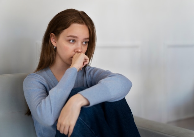 Foto gratuita vista lateral mujer preocupada sentada en el sofá