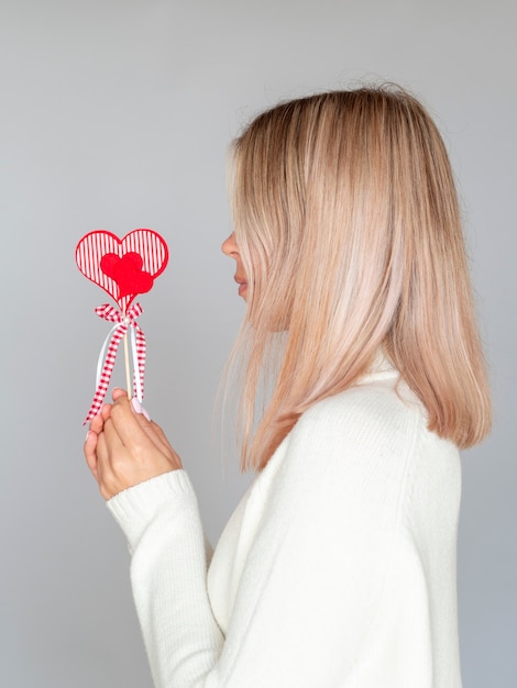 Foto gratuita vista lateral de la mujer que sostiene el corazón