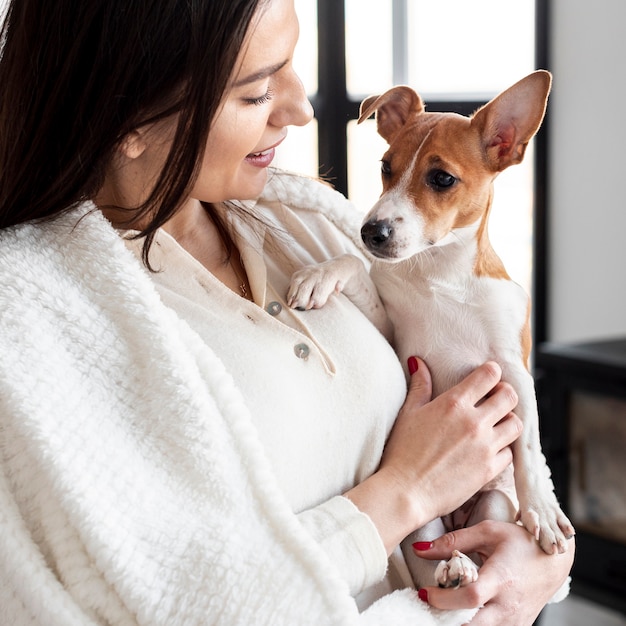 Foto gratuita vista lateral de la mujer que sostiene su perro