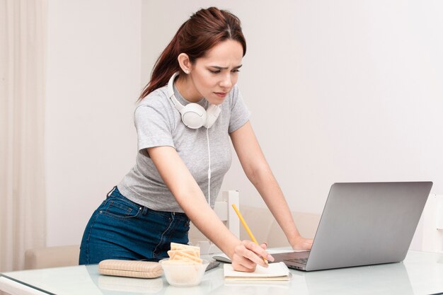 Vista lateral de la mujer que trabaja en la computadora portátil