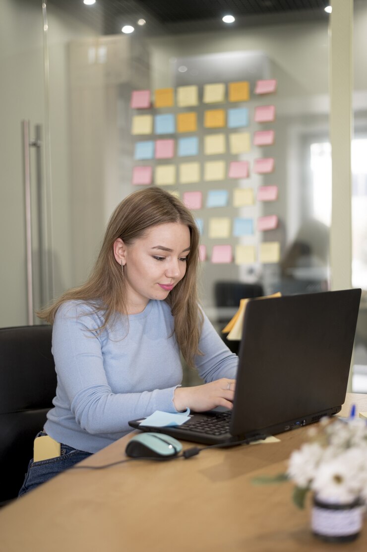 Foto gratuito vista lateral de la mujer que trabaja en la oficina en la computadora portátil