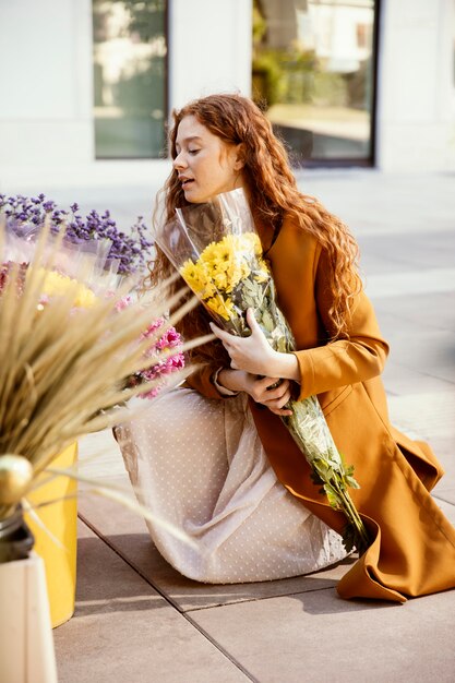 Vista lateral de la mujer recibiendo flores de primavera al aire libre