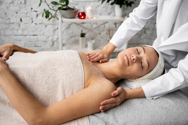 Vista lateral mujer recibiendo masajes en el spa