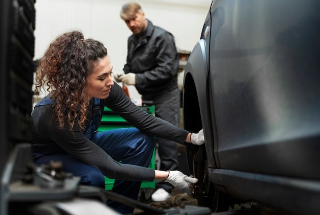 Vista lateral mujer reparando coche