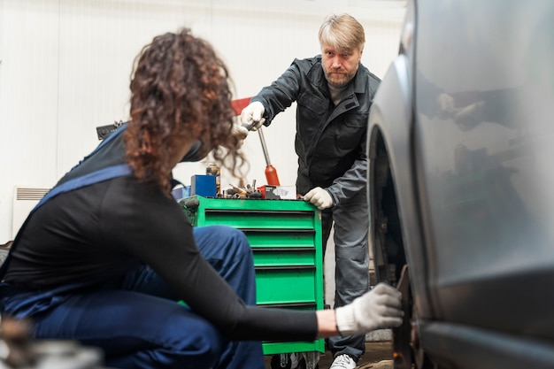 Foto gratuita vista lateral mujer reparando coche