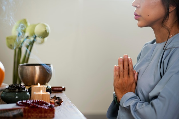 Foto gratuita vista lateral de la mujer rezando delante de velas