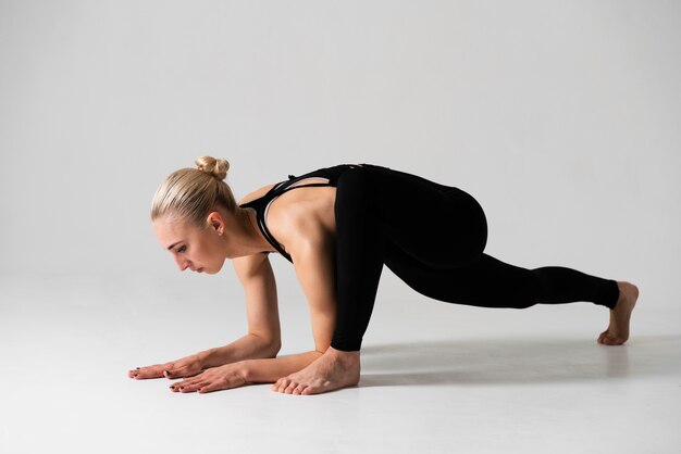 Vista lateral mujer rubia haciendo yoga