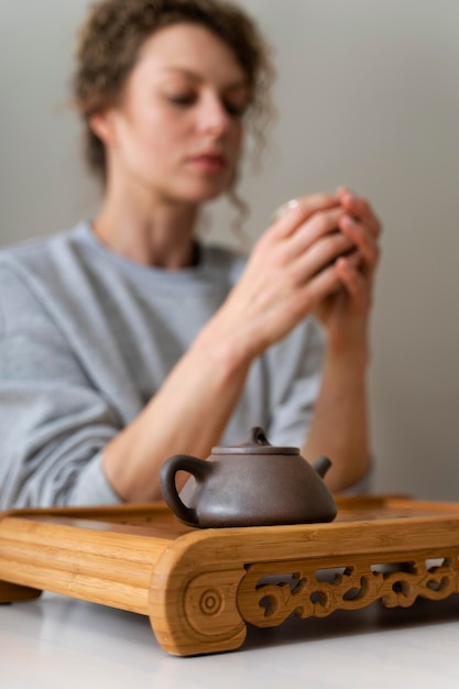 Vista lateral de una mujer rubia de pelo rizado bebiendo té y relajarse