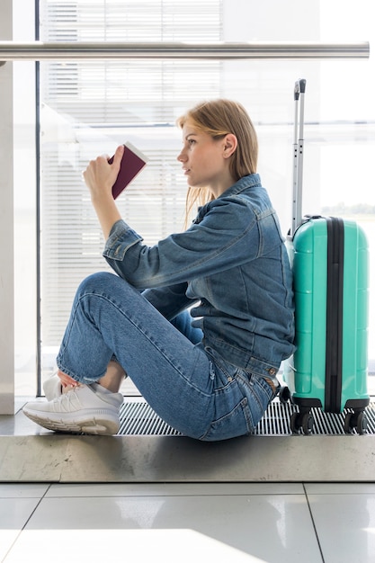 Foto gratuita vista lateral de la mujer sentada en el aeropuerto