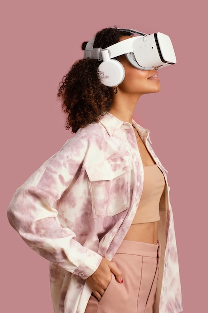 Foto gratuita vista lateral de la mujer sonriente con casco de realidad virtual