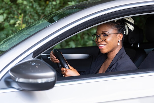 Foto gratuita vista lateral de la mujer sonriente conduciendo su coche personal