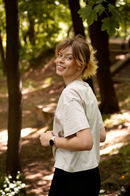 Vista lateral mujer sonriente corriendo en el bosque
