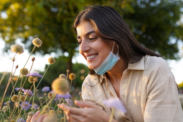 Foto gratuita vista lateral mujer sonriente oliendo flores